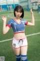 A woman in a soccer uniform posing in front of a net.