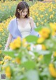 A woman standing in a field of yellow flowers.