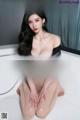 a woman sitting in a bathtub with her legs crossed