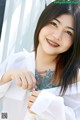 A woman with braces smiles at the camera. 