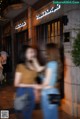 A couple of women standing next to each other on a sidewalk.