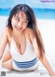 A woman in a white and blue bathing suit on the beach.