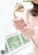 A woman holding a shower head in her hand.