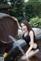 A woman in a black bathing suit sitting in a fountain.