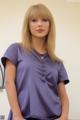A woman in a purple shirt is posing for a picture.